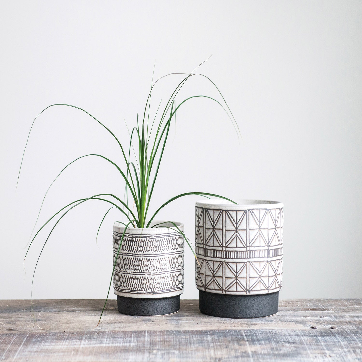 Set of two white stoneware planters with modern black designs